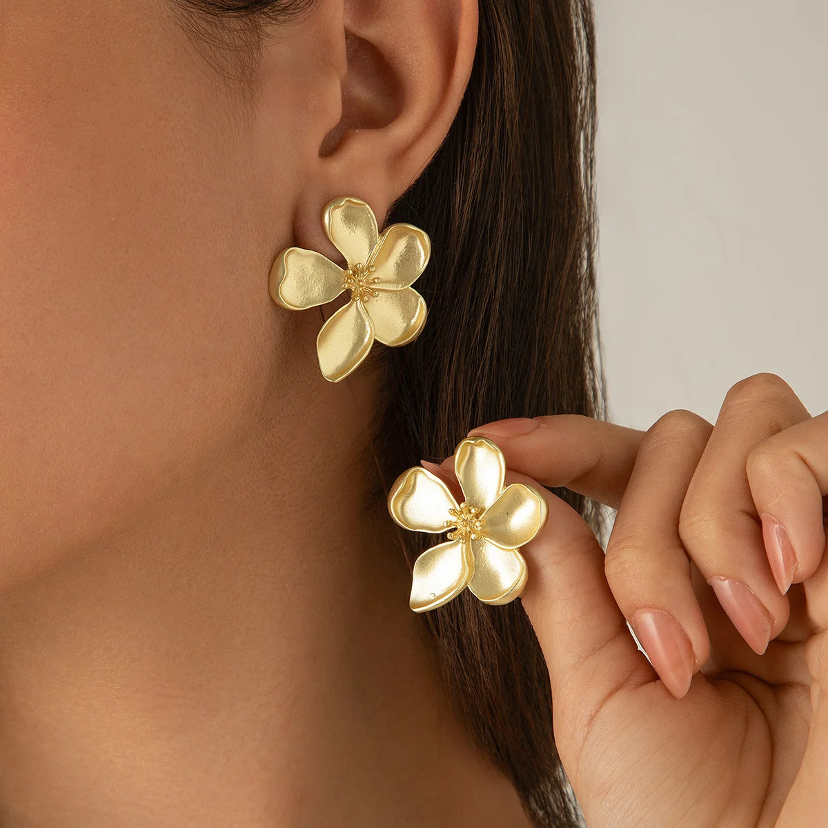 Image de boucles d'oreilles dorées en forme de fleur, avec des pétales finement sculptés et une finition brillante, de la collection automne 2024 de Rue Des Bijoux