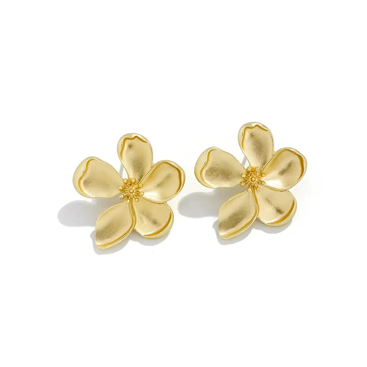 Boucles d'oreilles en forme de fleur dorée portées par une femme, avec des pétales délicatement sculptés et une finition brillante. Accessoire de la collection automne 2024 de Rue Des Bijou