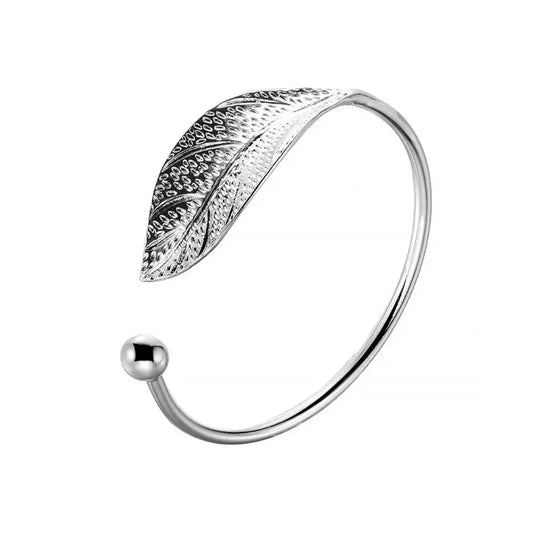 Bracelet en métal argenté avec un design délicat en forme de feuille, parfait pour ajouter une touche naturelle et élégante à toute tenue.