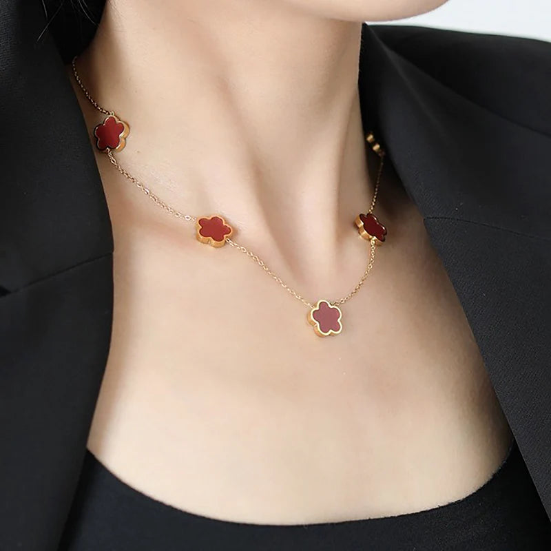 Collier Amaryllis avec pendentifs trèfle rouge, en acier inoxydable plaqué or 14K, disponible chez Rue des Bijoux, alliant élégance et modernité.