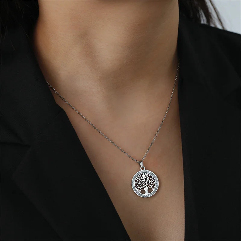 Une femme qui porte le collier Elina en acier inoxydable avec pendentif arbre de vie orné de zircons cubiques de Rue des Bijoux